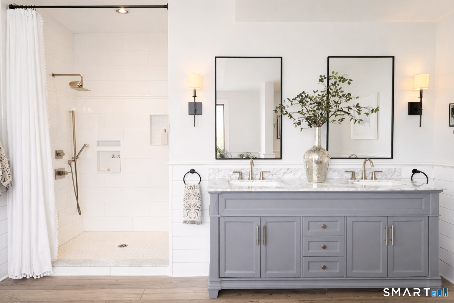 34 Orchard Road Milford, CT 06460 - Photo 16 of 25 a bathroom with a double vanity sink a mirror a bathtub and shower