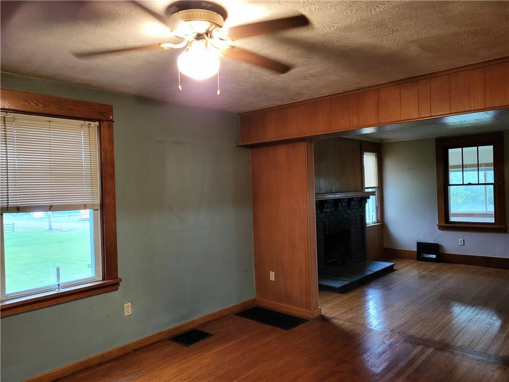 521 New Castle Road Slippery Rock, PA 16057 - Photo 7 of 25 a view of a livingroom with wooden floor and a ceiling fan