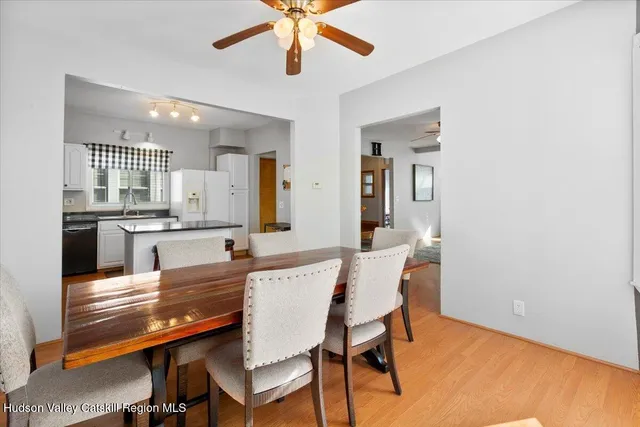 a kitchen with kitchen island granite countertop wooden floors and white cabinets