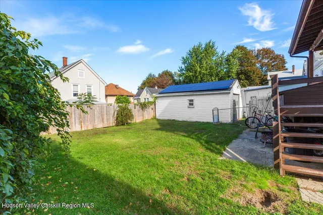 a view of a house with backyard and sitting area