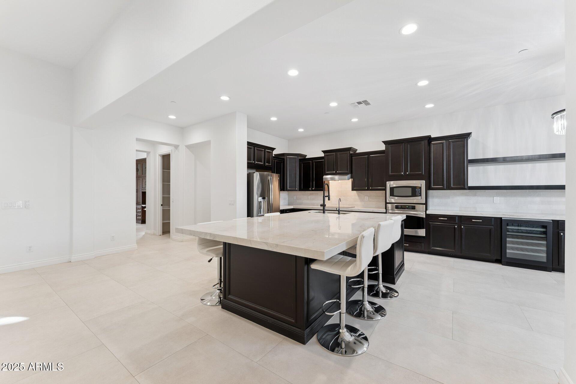 4547 South Banning Drive Gilbert, AZ 85297 - Photo 18 of 45 a large kitchen with a large counter top a sink stainless steel appliances and cabinets