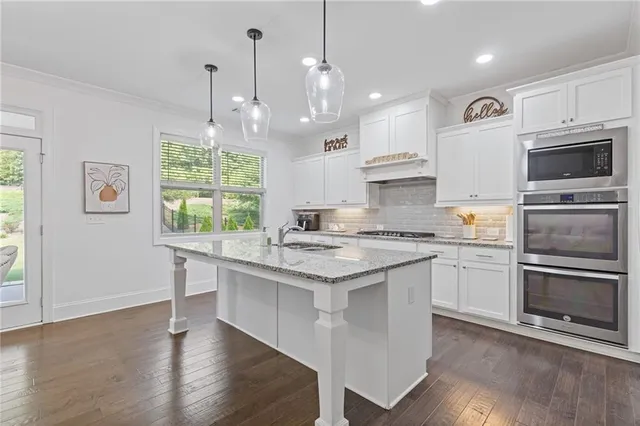 a kitchen with granite countertop a refrigerator and a sink