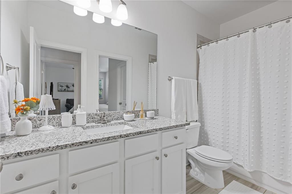 4867 Hunters Grove Way Sugar Hill, GA 30518 - Photo 27 of 61 a bathroom with a granite countertop sink vanity mirror and toilet