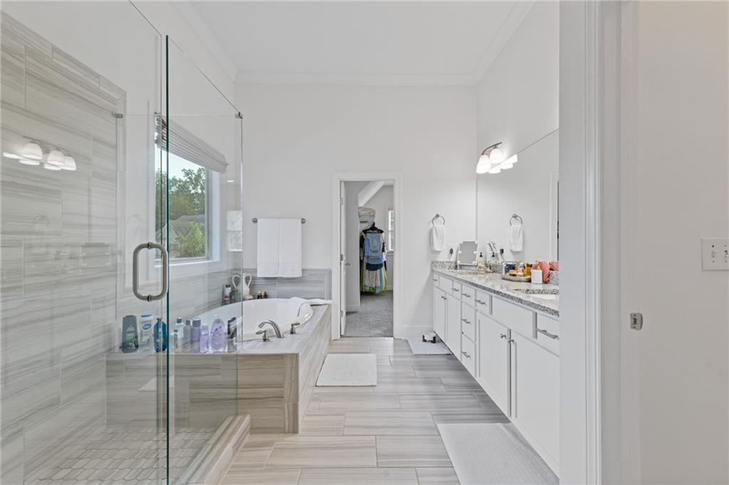 4867 Hunters Grove Way Sugar Hill, GA 30518 - Photo 33 of 61 a large bathroom with a tub sink and mirror