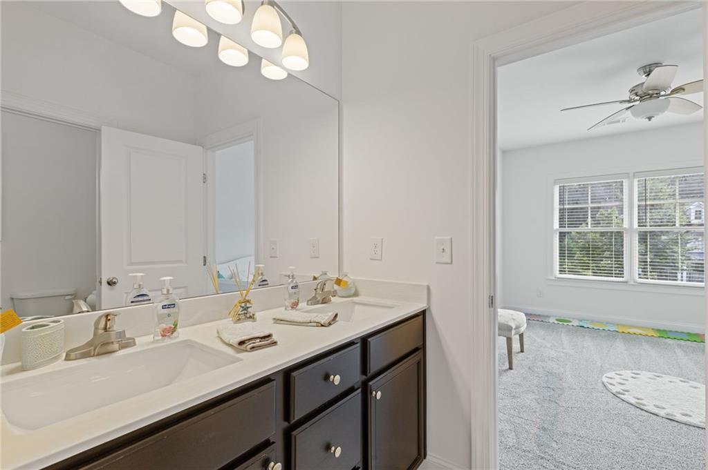 4867 Hunters Grove Way Sugar Hill, GA 30518 - Photo 43 of 61 a bathroom with a sink a vanity and a mirror
