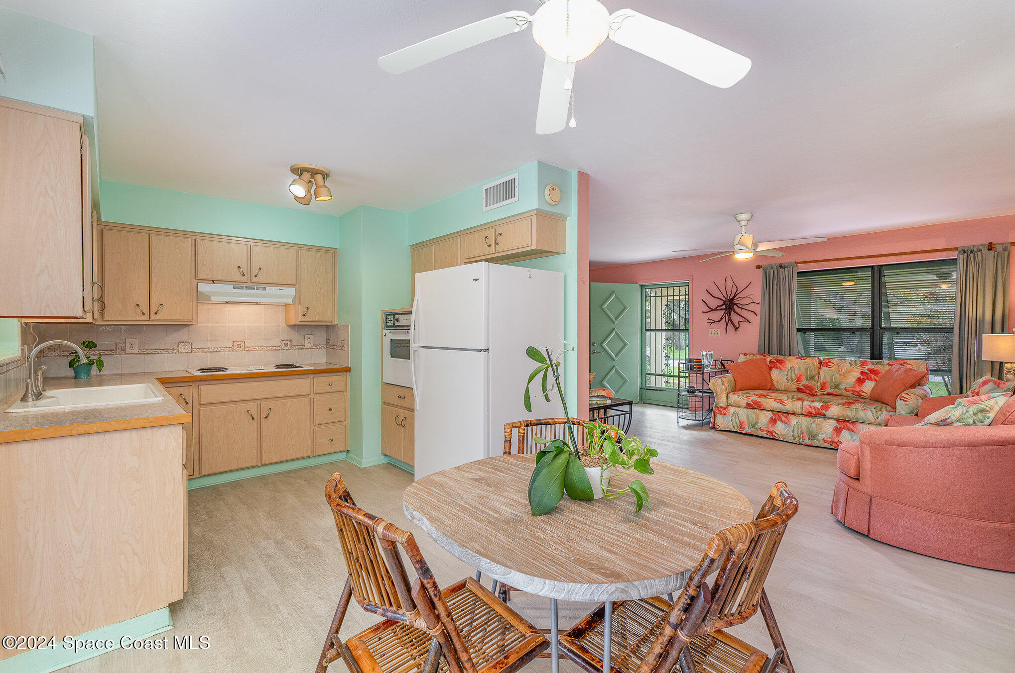 968 Trinidad Road Cocoa Beach, FL 32931 - Photo 5 of 20 a kitchen with refrigerator a stove and a dining table with wooden floor
