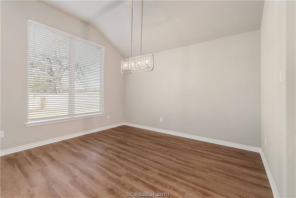 3185 Normandy Way Bryan, TX 77808 - Photo 7 of 16 a view of an empty room with wooden floor and a window