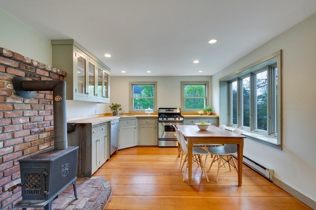 742 Barretts Mill Road Concord, MA 01742 - Photo 5 of 38 a kitchen with a table chairs a sink dishwasher stove and cabinets