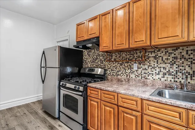 a kitchen with granite countertop a sink stove and cabinets