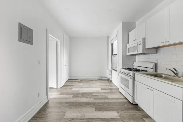 a kitchen with granite countertop white cabinets and white appliances