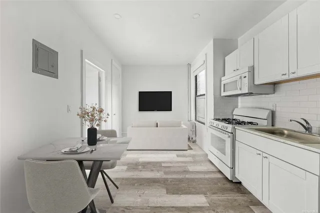 a kitchen with stainless steel appliances a white table and chairs