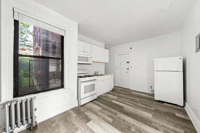 a kitchen with granite countertop white cabinets and white appliances