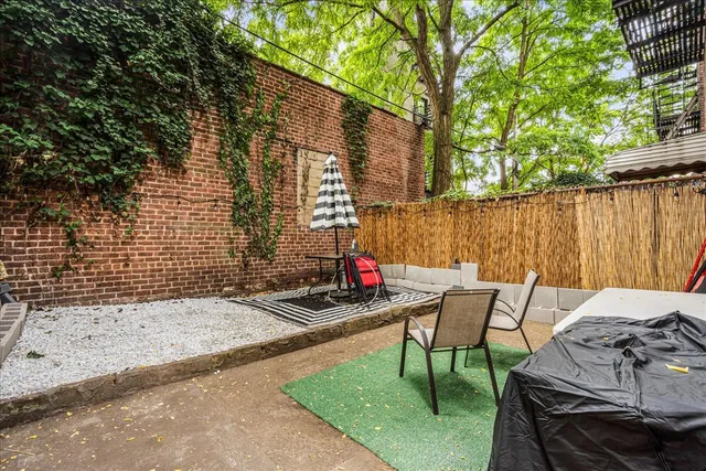 a view of backyard with table and chairs and wooden fence