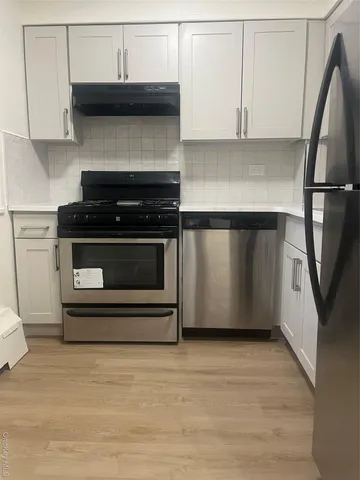 a kitchen with stainless steel appliances a stove and a microwave