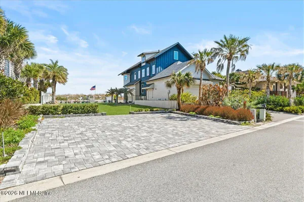 a view of a house with a yard and potted plants