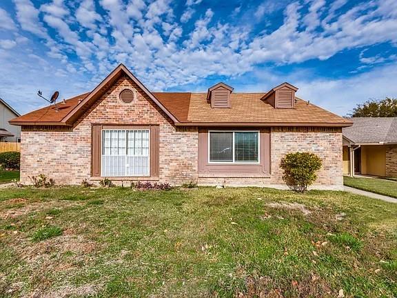 Single story home featuring a front lawn and brick siding