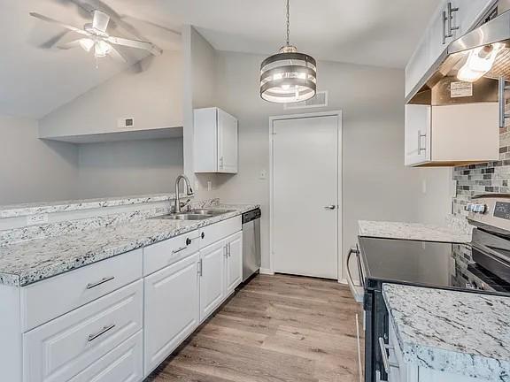7125 Sorcey Road Dallas, TX 75249 - Photo 5 of 10 Kitchen featuring appliances with stainless steel finishes, under cabinet range hood, white cabinets, and light wood-type flooring