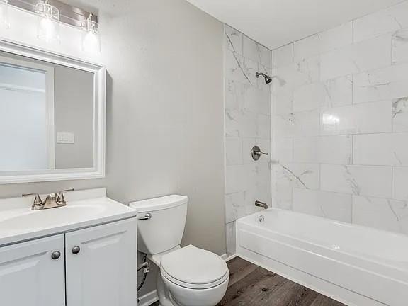 7125 Sorcey Road Dallas, TX 75249 - Photo 8 of 10 Bathroom featuring bathtub / shower combination, dark wood-style floors, and vanity