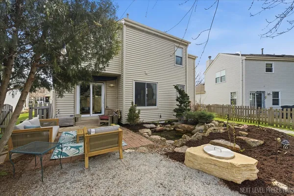 a view of a patio with couches table and chairs with wooden fence