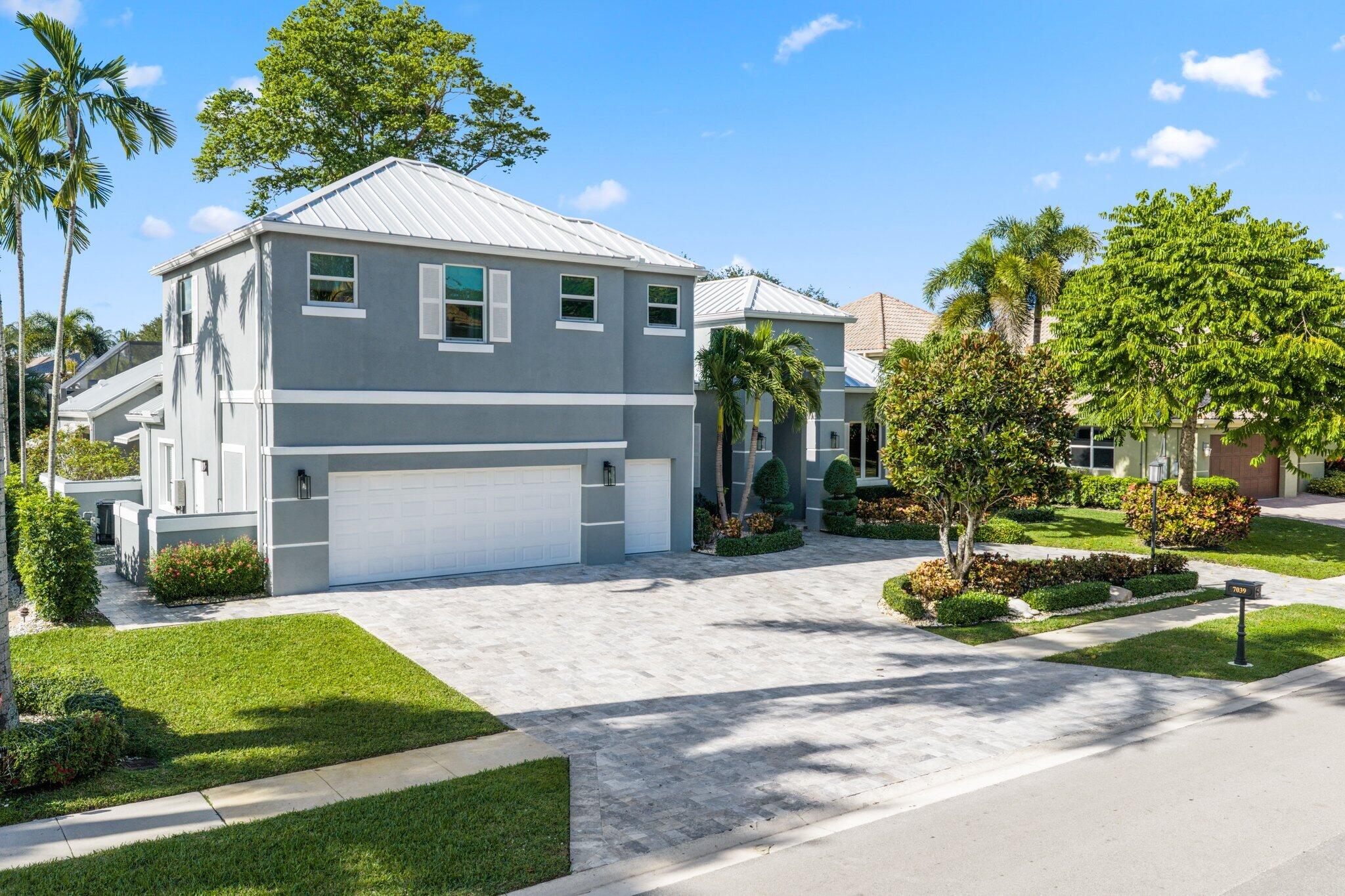 7039 Mandarin Drive Boca Raton, FL 33433 - Photo 1 of 52 a front view of a house with a yard