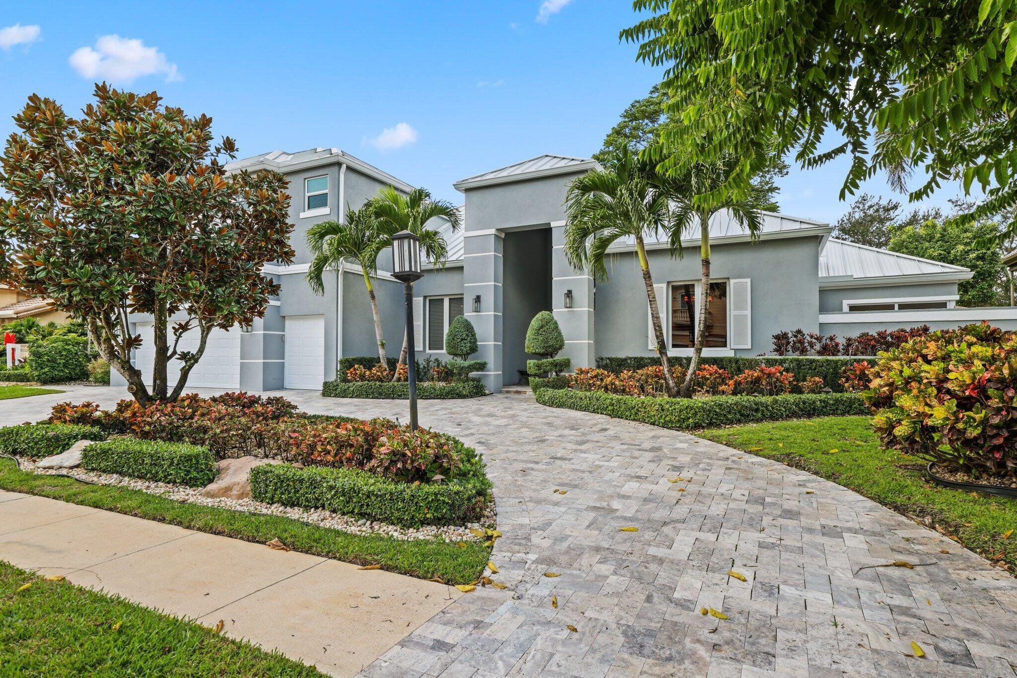 7039 Mandarin Drive Boca Raton, FL 33433 - Photo 2 of 52 a front view of a house with a garden