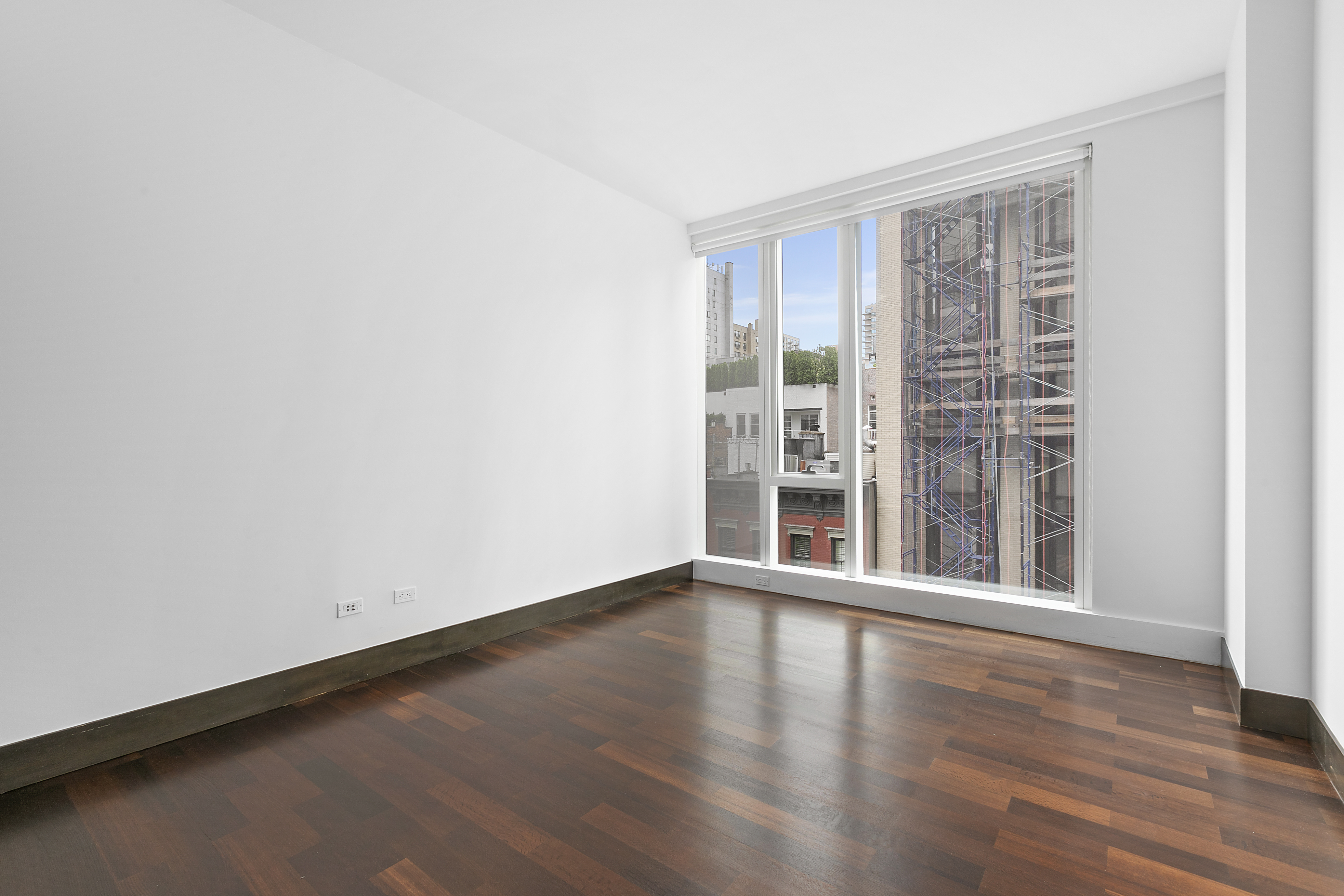 151 East 85th Street, Unit 6B Manhattan, NY 10028 - Photo 1 of 10 an empty room with wooden floor and windows
