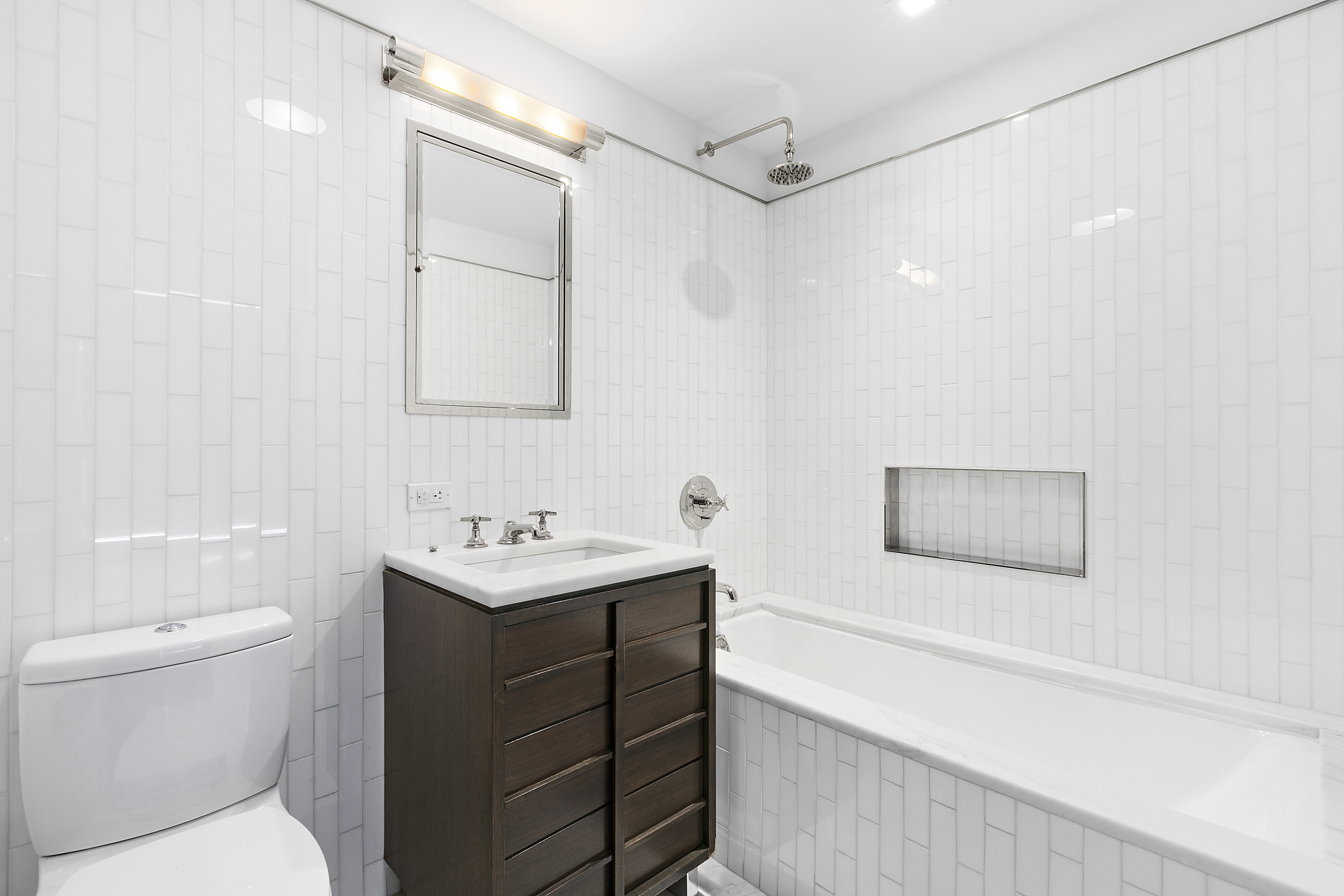 151 East 85th Street, Unit 6B Manhattan, NY 10028 - Photo 4 of 10 a bathroom with a sink toilet vanity and shower