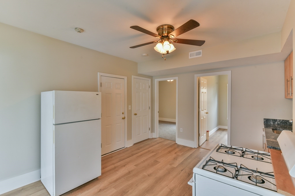 4 Agate Avenue Worcester, MA 01604 - Photo 8 of 39 a kitchen with a refrigerator a stove top oven and a chandelier