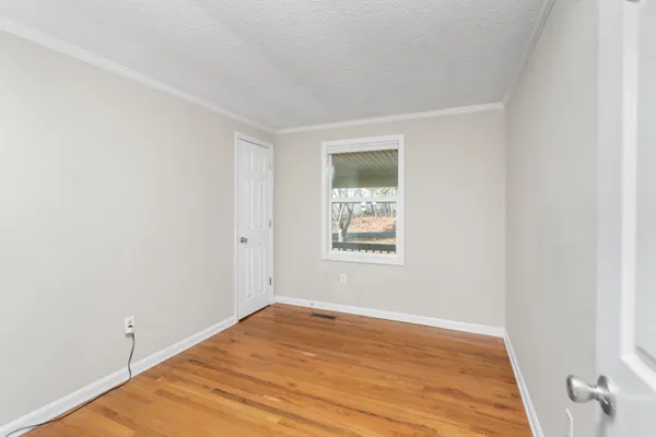 a view of hallway with a large window and wooden floor