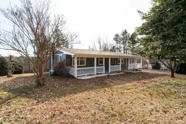 a front view of house with yard and trees in the background