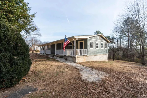 a front view of house with yard and trees in the background
