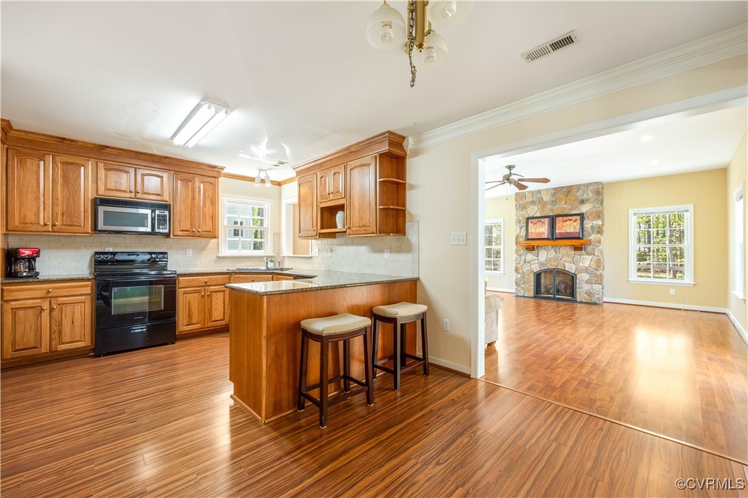 15221 Windy Ridge Road Midlothian, VA 23112 - Photo 6 of 30 a kitchen with stainless steel appliances granite countertop a refrigerator a stove top oven a sink dishwasher and wooden cabinets with wooden floor