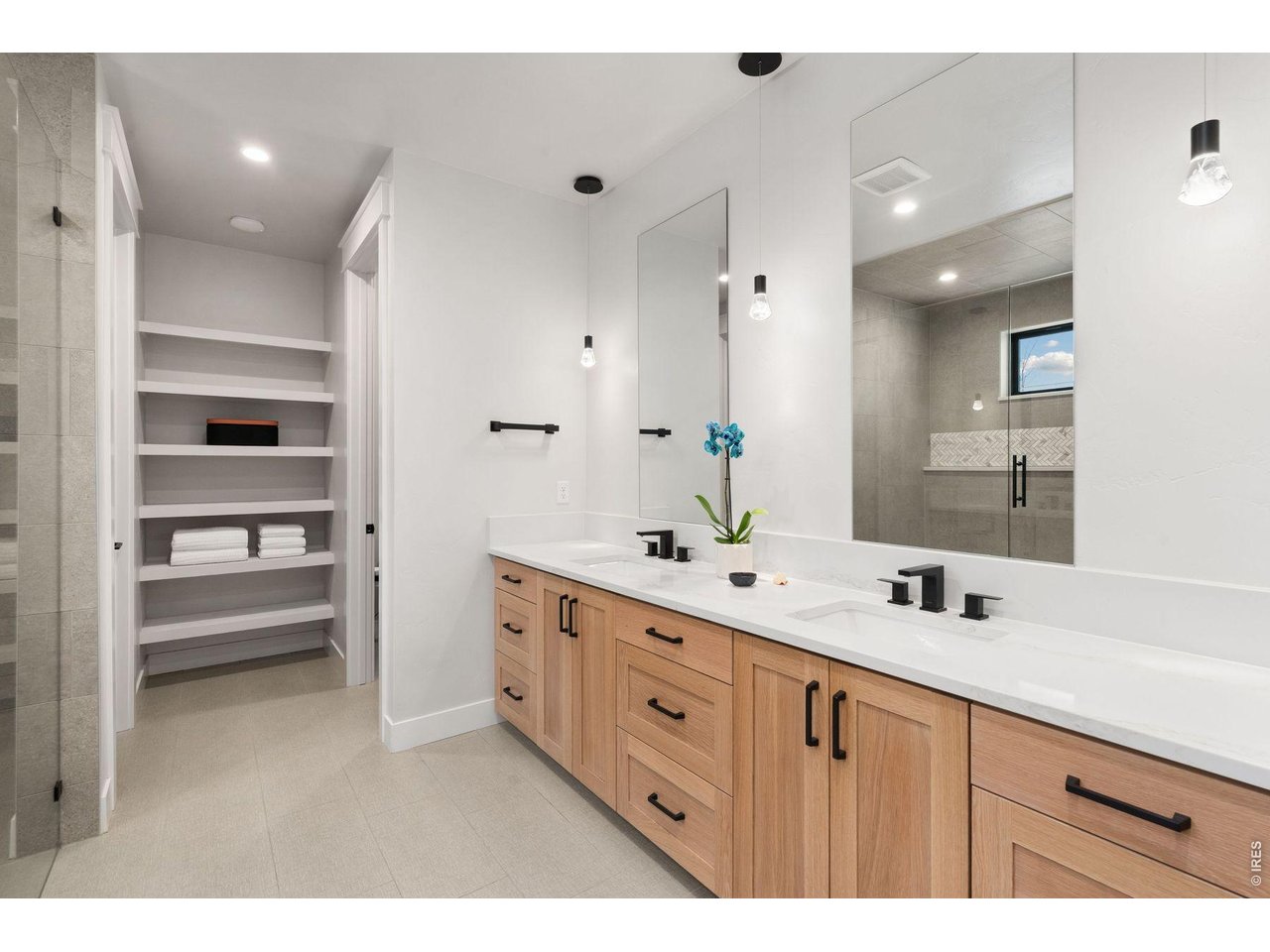 2311 Sugarloaf Road Berthoud, CO 80513 - Photo 13 of 49 a bathroom with a double vanity sink a mirror and a shower