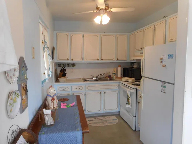 a kitchen with a refrigerator a stove and white cabinets