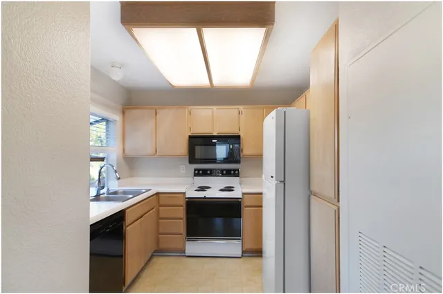 a kitchen with a refrigerator and a stove top oven