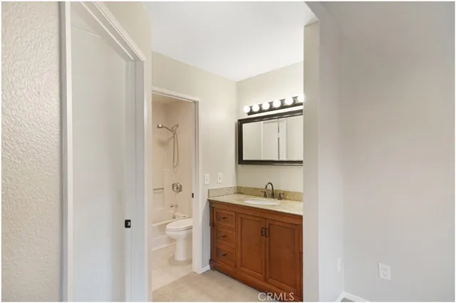 a spacious bathroom with a granite countertop sink and a mirror