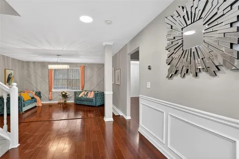 a living room with furniture and a wooden floor