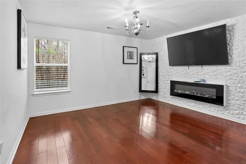a view of a livingroom with wooden floor and a flat screen tv