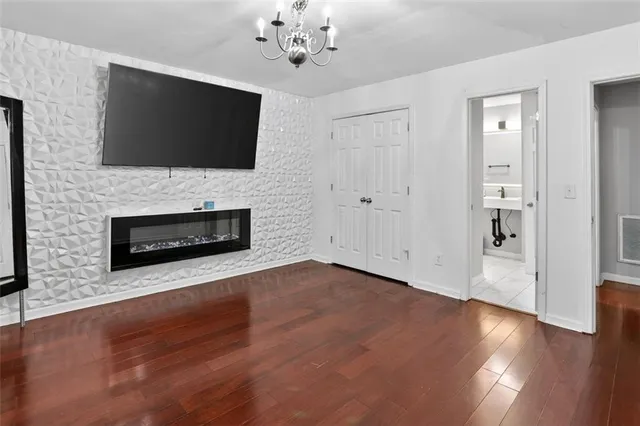 a view of a livingroom with wooden floor and a flat screen tv