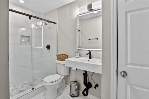 a bathroom with a sink toilet and shower