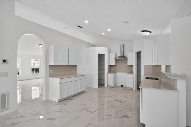 a kitchen with white cabinets and white appliances