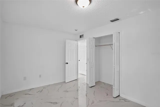 an empty room with fan and entrance