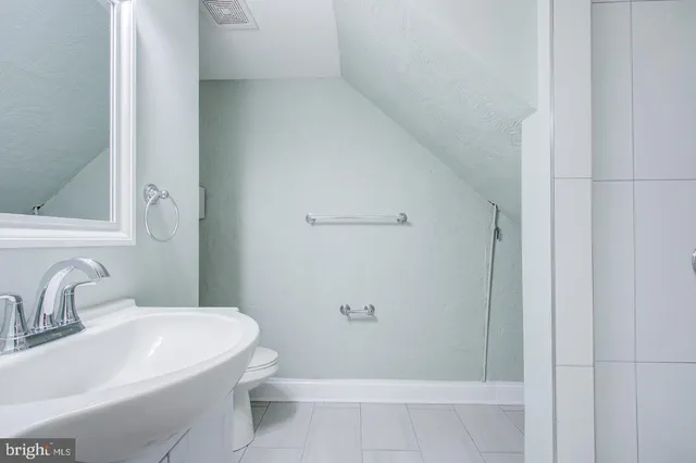 a bathroom with a toilet a sink and a mirror
