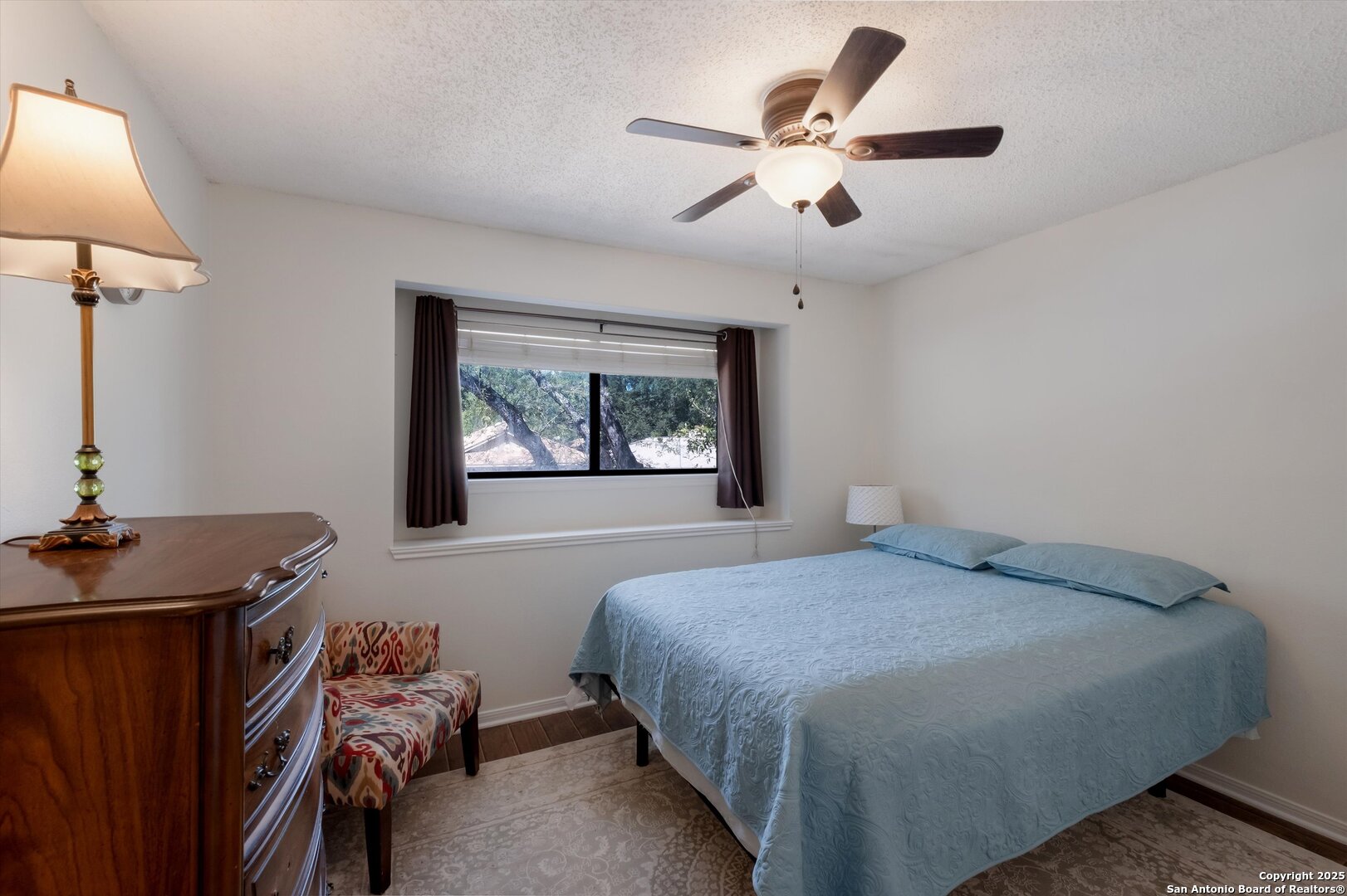 5738 Spring Sunshine San Antonio, TX 78247 - Photo 16 of 22 a bedroom with a bed and a chandelier