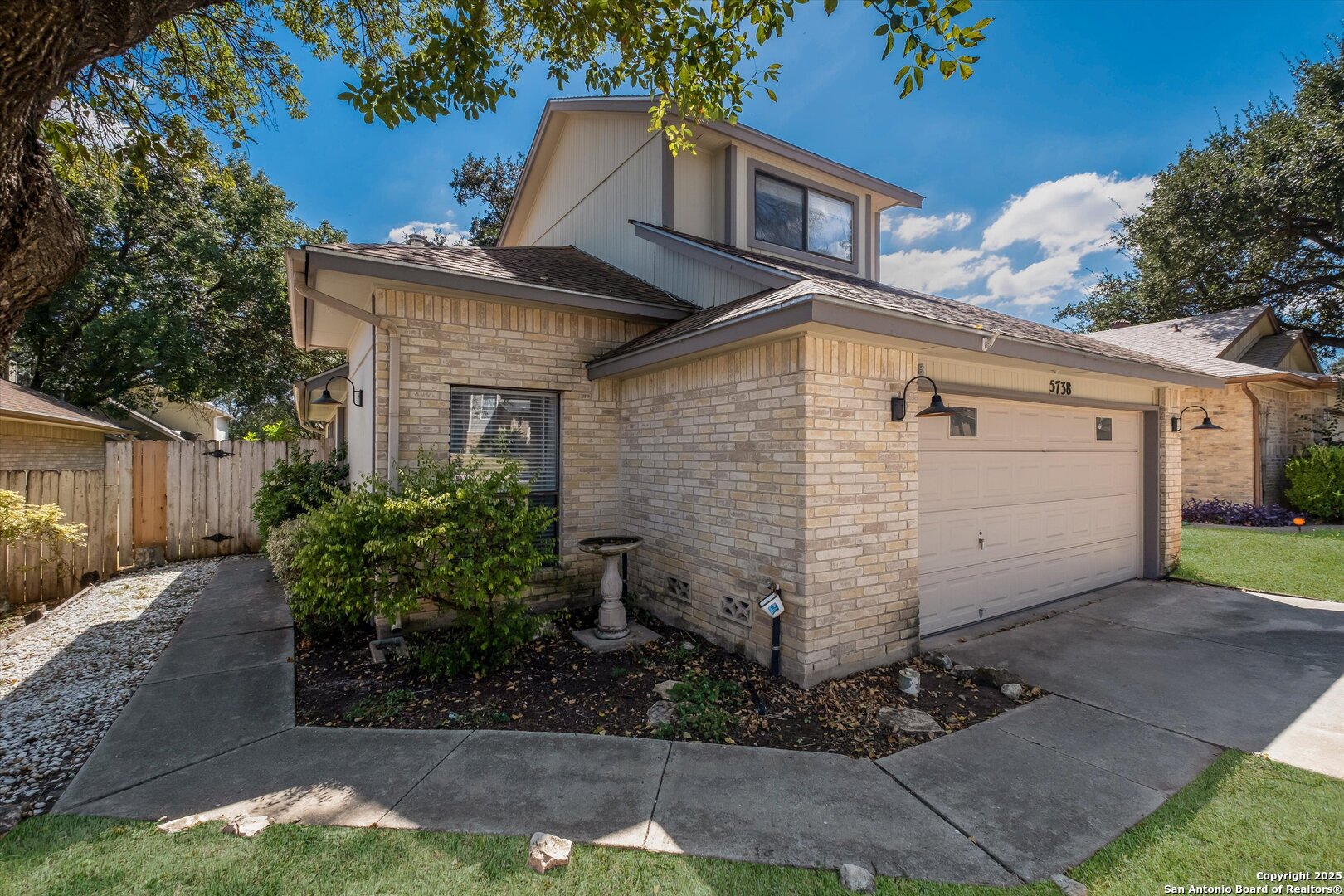 5738 Spring Sunshine San Antonio, TX 78247 - Photo 3 of 22 a view of a white house with a small yard plants and large tree