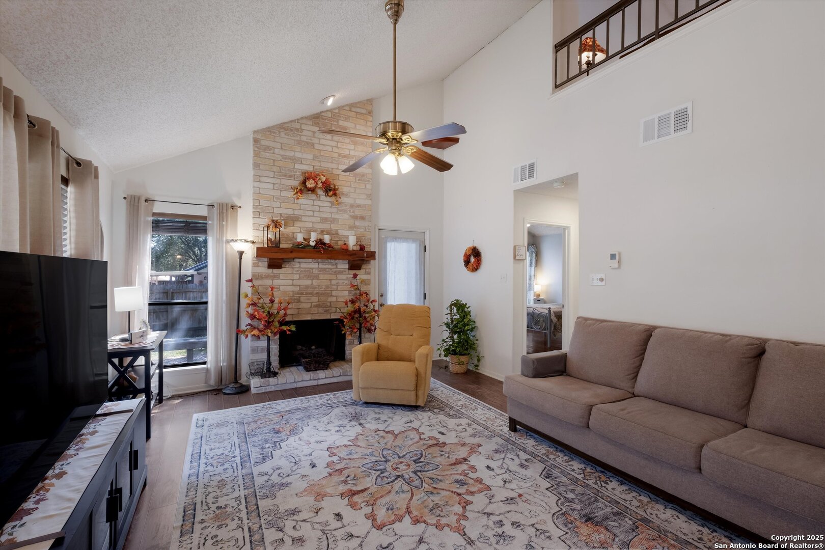5738 Spring Sunshine San Antonio, TX 78247 - Photo 6 of 22 a living room with furniture a fireplace and a flat screen tv