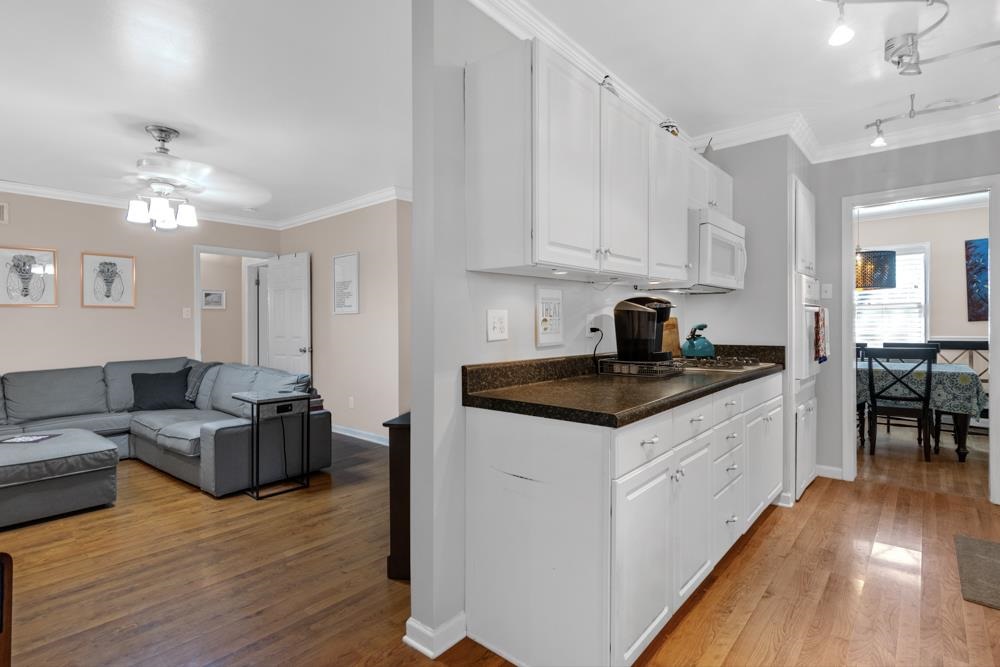 5218 Quince Road Memphis, TN 38117 - Photo 5 of 25 a kitchen with granite countertop a stove top oven a sink dishwasher and white cabinets with wooden floor