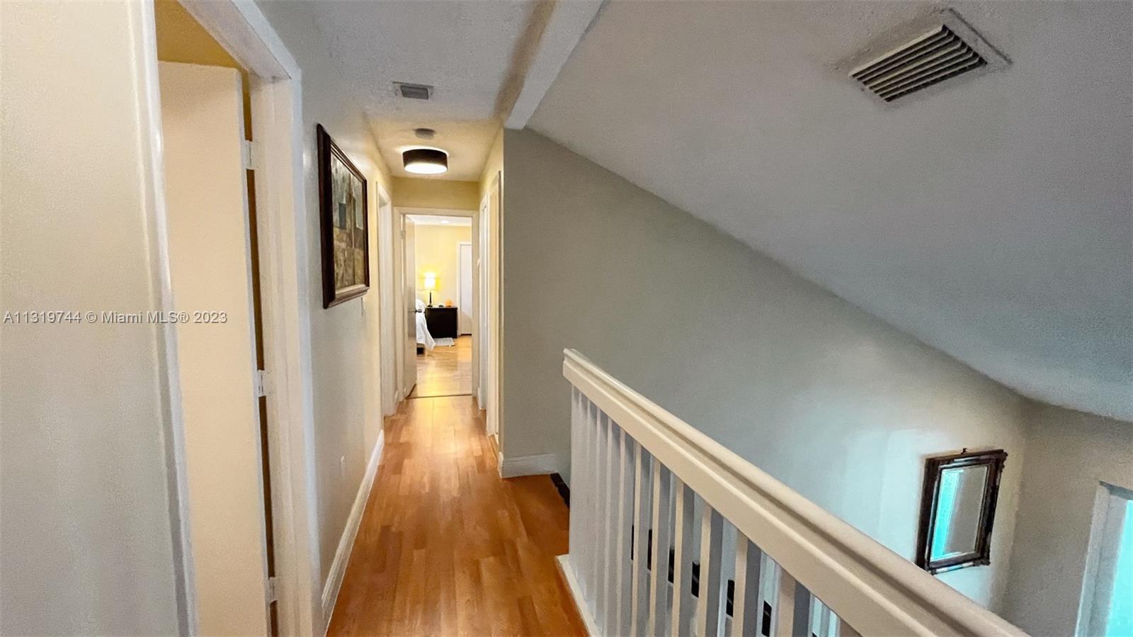 11990 Southwest 92nd Street Miami, FL 33186 - Photo 17 of 33 a view of a hallway with wooden floor and staircase