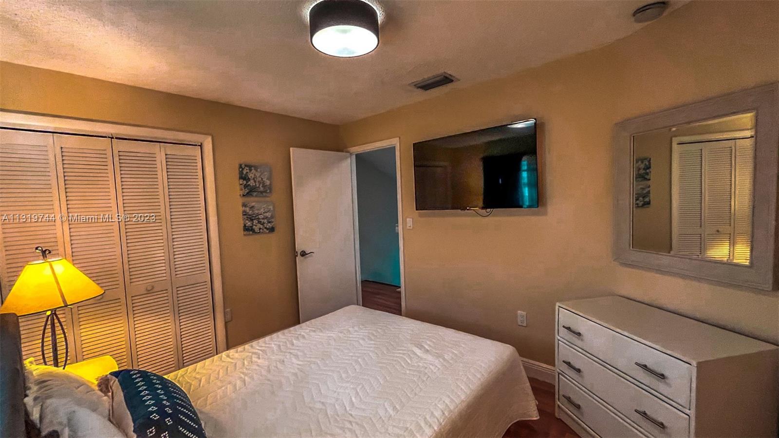 11990 Southwest 92nd Street Miami, FL 33186 - Photo 18 of 33 a bedroom with a bed and a lamp