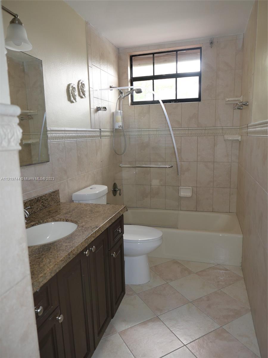 11990 Southwest 92nd Street Miami, FL 33186 - Photo 19 of 33 a bathroom with a granite countertop sink a toilet and shower